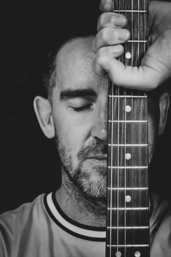 John Barrett holding a guitar